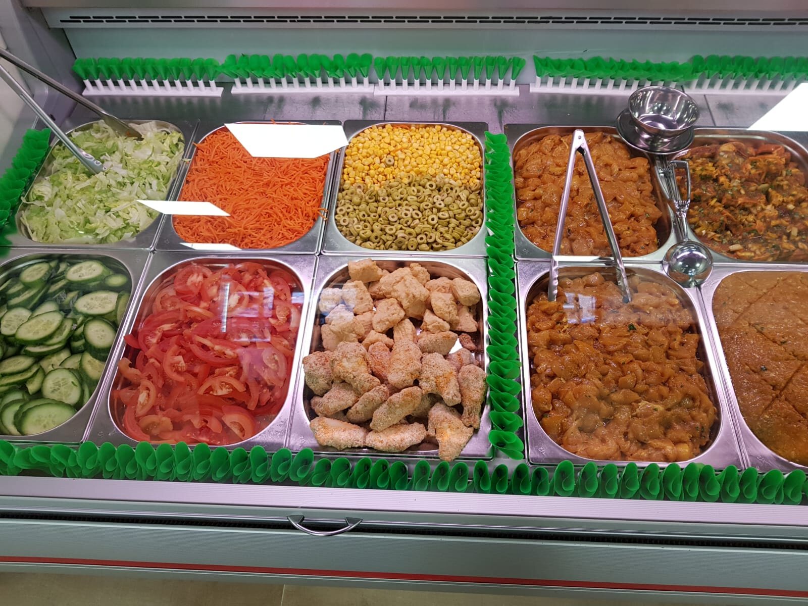 De verse vitrine met dagvers gemarineerd vlees, vis en salades